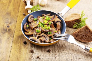 Masanın üzerinde tavada kızartılmış mantarlar.