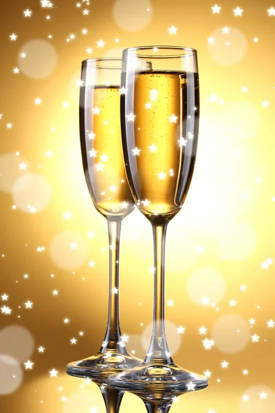 Two glasses of champagne on bright background with lights — Stock Photo, Image