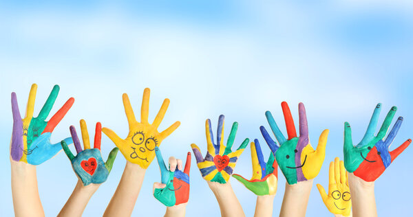 Painted hands with smile on blue background