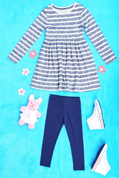 Piękne ubrania dla dziewczynki na niebieskim tle — Zdjęcie stockowe