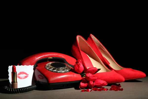 Piękne czerwone buty kobiece i telefon retro, na czarnym tle — Zdjęcie stockowe