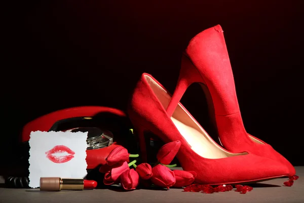 Piękne czerwone buty kobiece i telefon retro, na czarnym tle — Zdjęcie stockowe