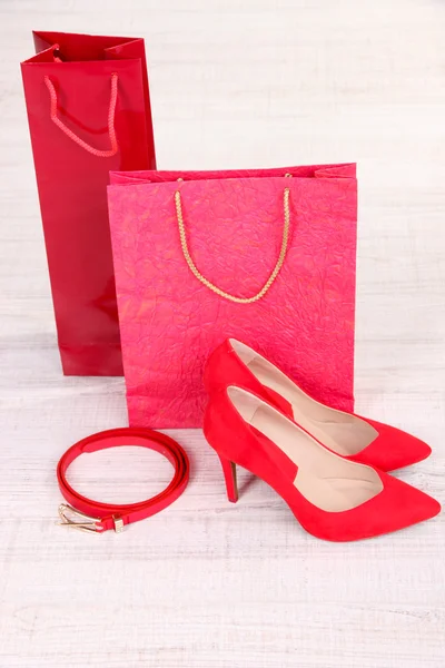 Hermosos zapatos femeninos rojos, cinturones y bolsas de compras —  Fotos de Stock