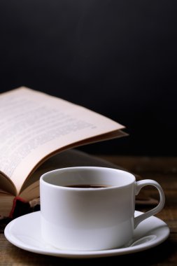 sıcak kahve ile masaya koyu arka plan üzerinde kitap