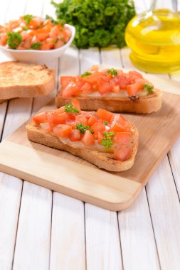 Kesme tahtasında domatesli lezzetli bruschetta.