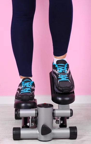 Woman doing exercise on stepper. Close-up on legs. — Stock Photo, Image