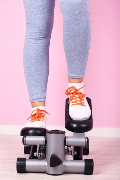 Woman doing exercise on stepper. Close-up on legs. — Stock Photo, Image