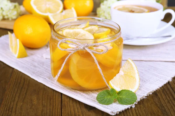 Leckere Zitronenmarmelade mit einer Tasse Tee auf dem Tisch in Großaufnahme — Stockfoto