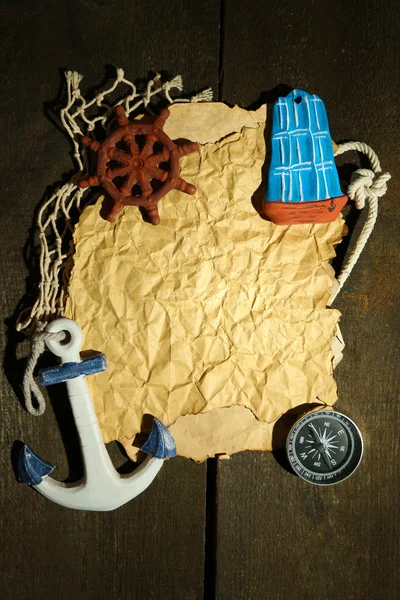Старая бумага с морскими аксессуарами, изолированная на деревянном фоне — стоковое фото