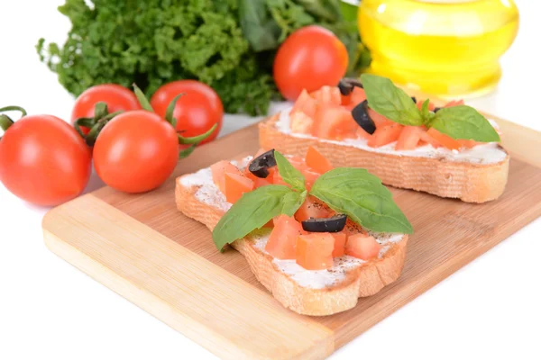 Deliciosa bruschetta con tomates en la tabla de cortar de cerca —  Fotos de Stock