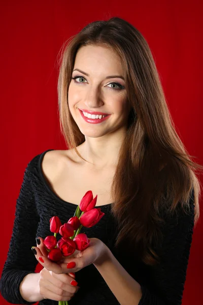 Attractive woman with flowers on color background — Stock Photo, Image