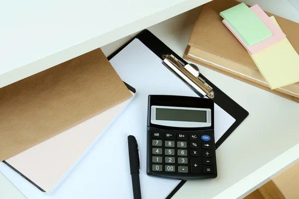 Office supplies in open desk drawer close up