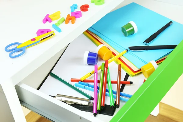 School supplies in open desk drawer close up — Stock Photo, Image