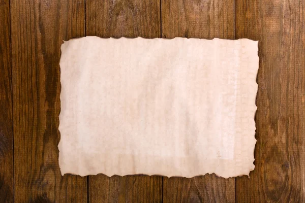 Oud papier op houten ondergrond — Stockfoto