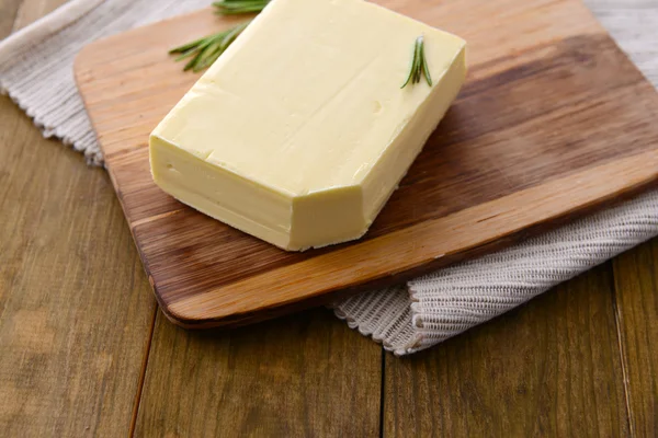 Tasty butter on wooden cutting board — Stock Photo, Image