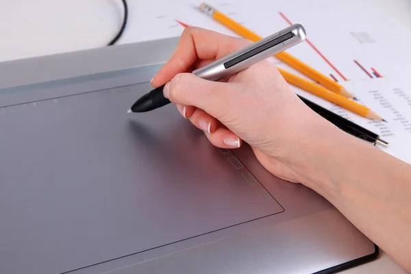 Vrouwelijke hand met grafisch tablet op tafel close-up — Stockfoto