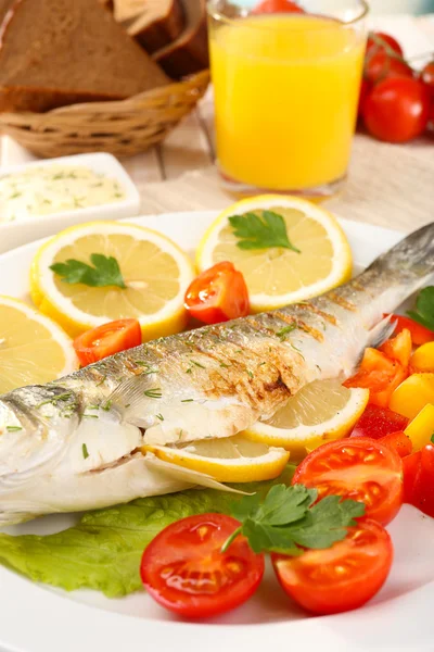 Delicious grilled fish on plate on table close-up — Stock Photo, Image