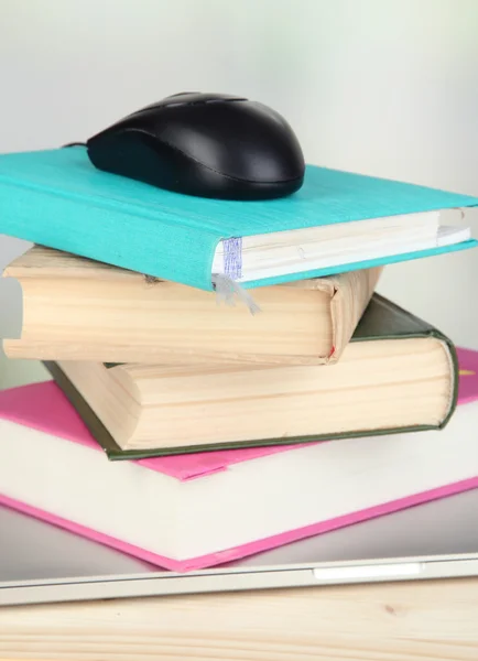 Ordenador ratón en los libros y portátil en la mesa de madera en el fondo de la habitación —  Fotos de Stock