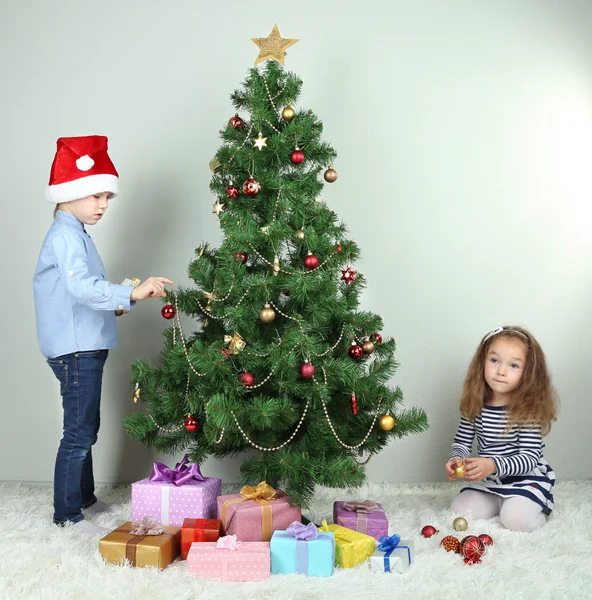 Kinder schmücken Weihnachtsbaum mit Kugeln im Zimmer — Stockfoto