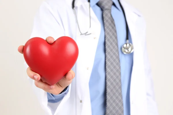 Homme Docteur avec le coeur rouge dans les mains, isolé sur fond blanc — Photo