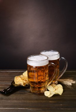 bardak bira ile masaya koyu arka plan üzerinde snack