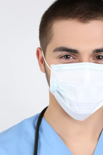 Jovem médico do sexo masculino em máscara médica, close-up, isolado em branco — Fotografia de Stock
