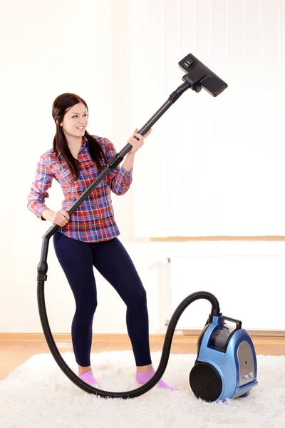 Beautiful young woman with vacuum cleaner in room — Stock Photo, Image