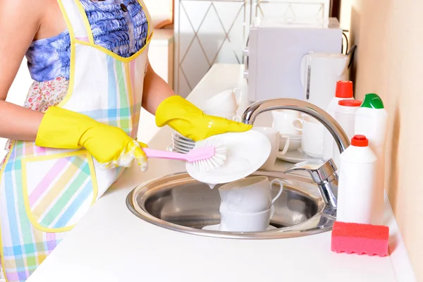 Hermosa joven lavando platos en la cocina — Foto de Stock