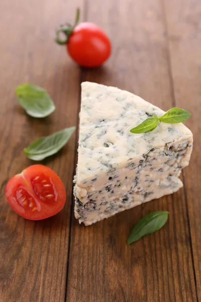 Queijo azul saboroso com manjericão e tomate, sobre mesa de madeira — Fotografia de Stock