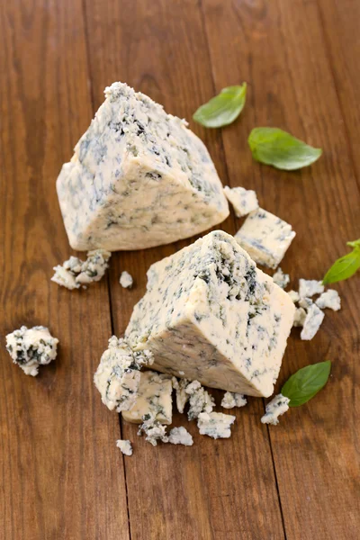 Savoureux fromage bleu au basilic, sur table en bois — Photo