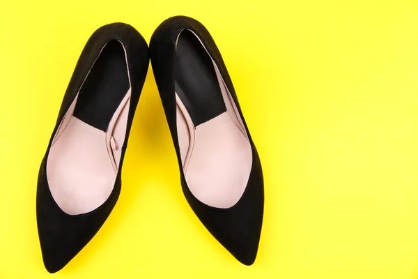 Hermosos zapatos femeninos negros, sobre fondo amarillo — Foto de Stock