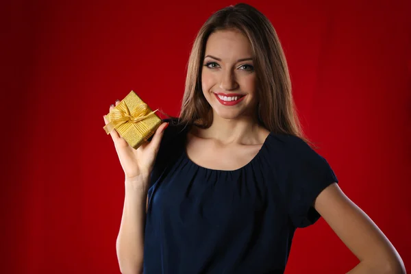 Mujer atractiva con caja de regalo, sobre fondo de color —  Fotos de Stock