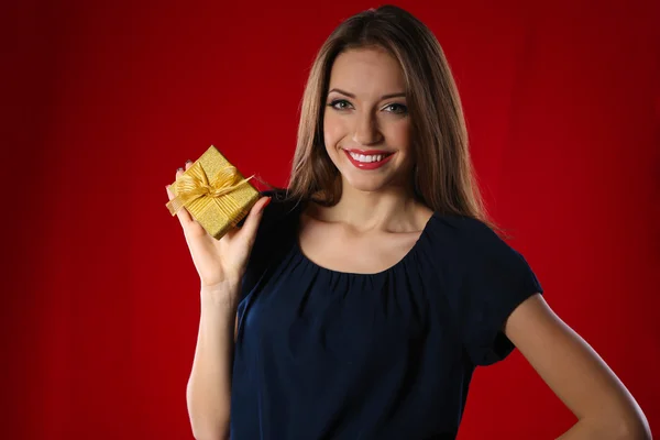 Mujer atractiva con caja de regalo, sobre fondo de color — Foto de Stock