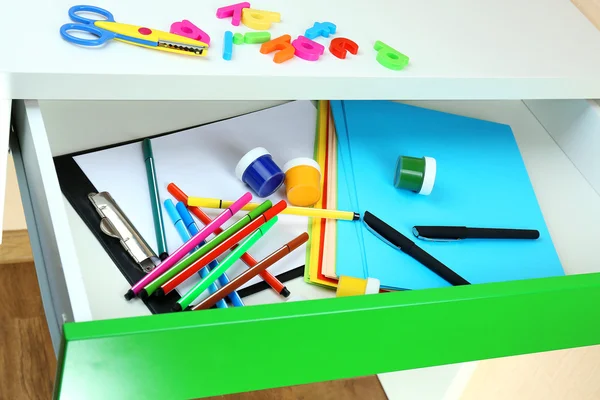 School supplies in open desk drawer close up — Stock Photo, Image