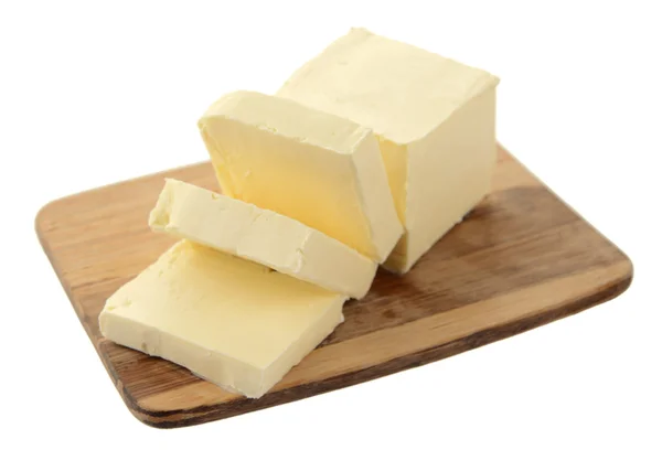 Leckere Butter auf hölzernem Schneidebrett isoliert auf weiß — Stockfoto