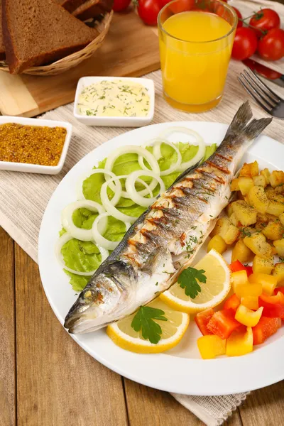 Delicioso pescado a la parrilla en el plato en primer plano de la mesa —  Fotos de Stock
