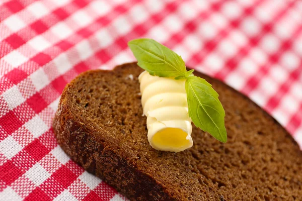 Fatia de pão de centeio com manteiga, na toalha de mesa — Fotografia de Stock