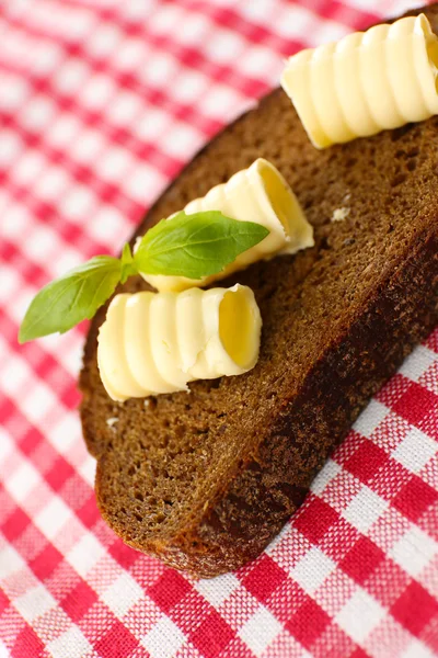 Tranche de pain de seigle au beurre, sur la nappe — Photo