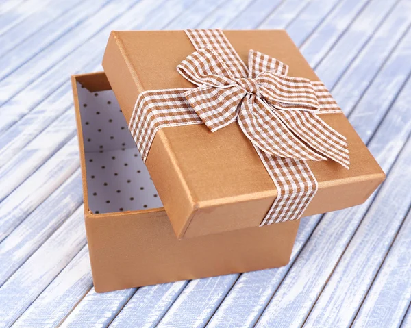 Caja de regalo abierta sobre fondo de madera — Foto de Stock