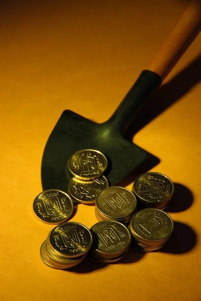 Mynt med spade på brun bakgrund — Stockfoto