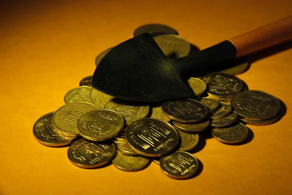 Mynt med spade på brun bakgrund — Stockfoto