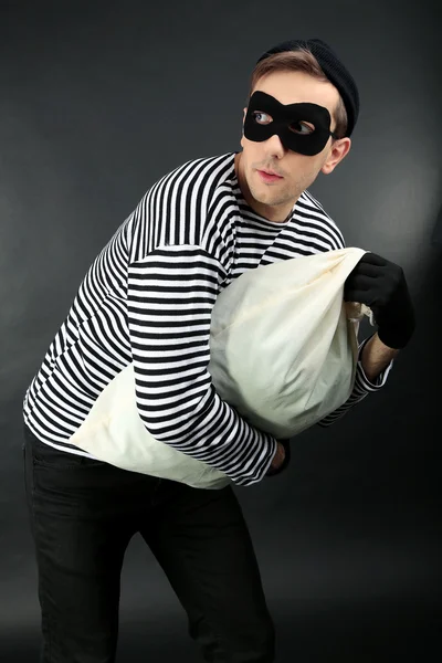 Ladrón con bolsa sobre fondo oscuro — Foto de Stock