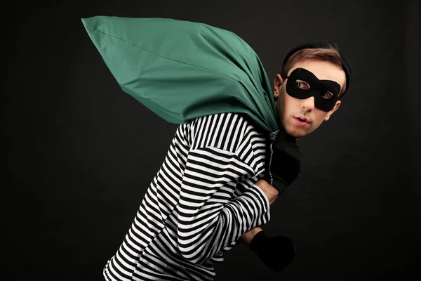 Thief with bag isolated on black — Stock Photo, Image