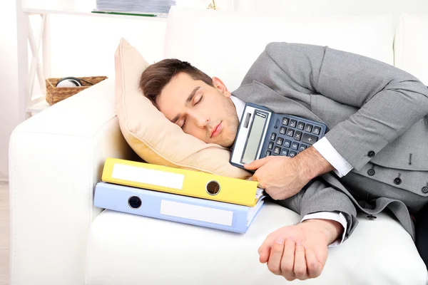 Элегантный молодой бизнесмен спит на диване, дома — стоковое фото
