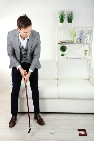Eleganter junger Geschäftsmann spielt zu Hause Minigolf — Stockfoto