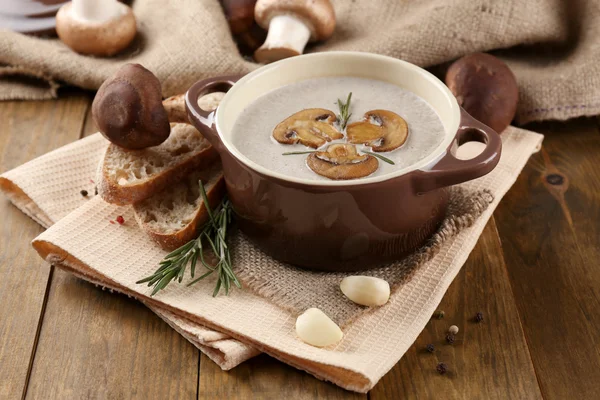 Mushroom soup in pot, on wooden background — Stock Photo, Image
