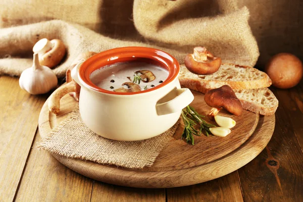 Soupe aux champignons en pot, sur table en bois, sur fond de sac — Photo