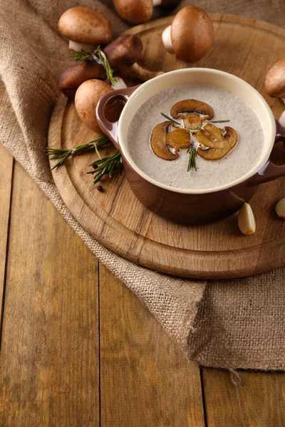 Composición con sopa de champiñones en olla, champiñones frescos y secos, sobre mesa de madera, sobre fondo de saco — Foto de Stock