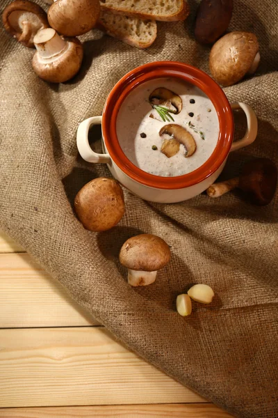 Champignonsoep in pot, op servet, op houten achtergrond — Stockfoto