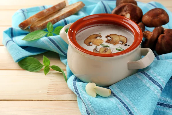 Pilzsuppe im Topf, auf Serviette, auf Holzgrund — Stockfoto